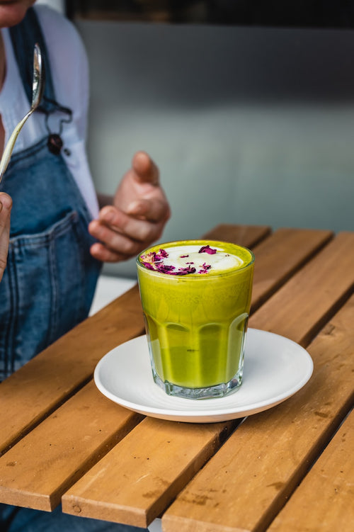 Cliente disfrutando un matcha latte en cafetería