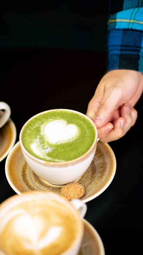 Disfrutando un matcha latte con arte en forma de corazón